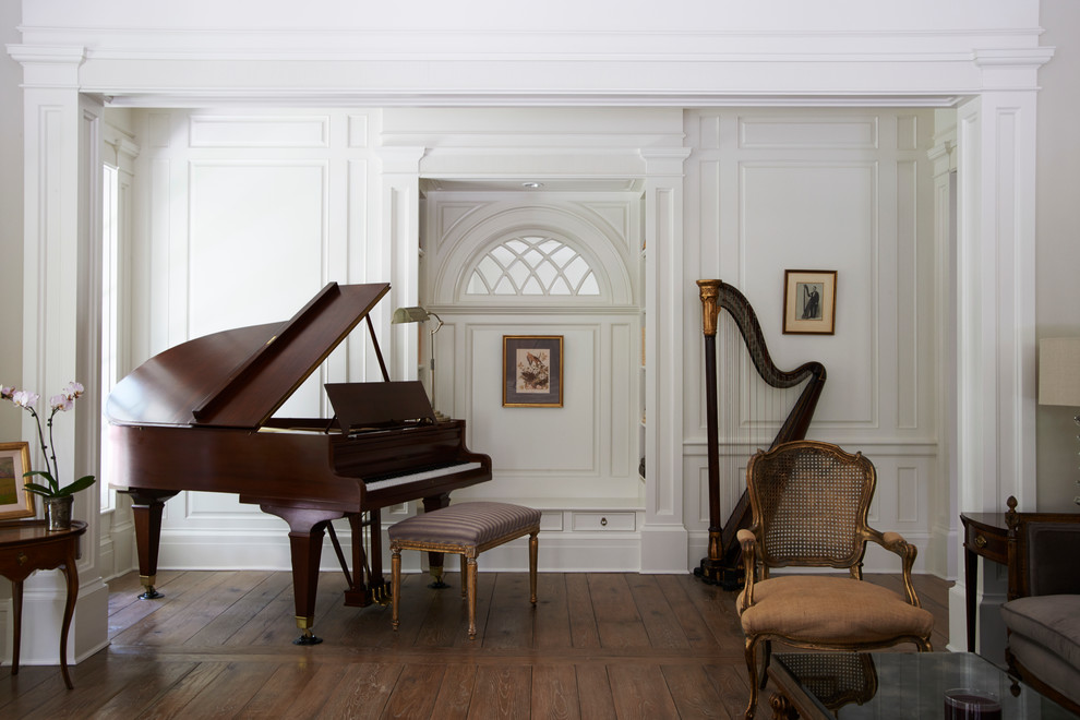 Example of a large classic enclosed medium tone wood floor and brown floor living room design in New York with a music area and white walls