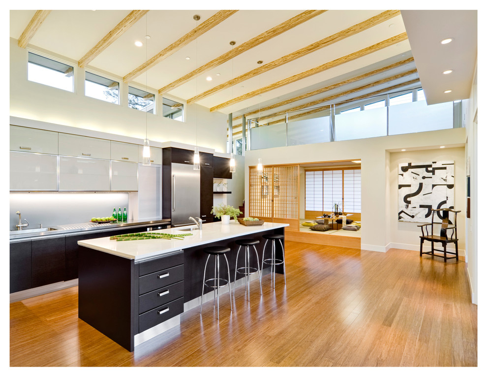 Inspiration for a large modern l-shaped open plan kitchen in San Francisco with a single-bowl sink, flat-panel cabinets, dark wood cabinets, quartzite benchtops, grey splashback, glass sheet splashback, stainless steel appliances, bamboo floors and with island.