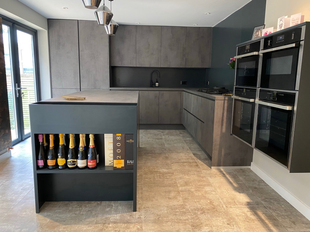 Inspiration for a mid-sized contemporary eat-in kitchen in Manchester with a drop-in sink, flat-panel cabinets, grey cabinets, laminate benchtops, black splashback, stainless steel appliances, porcelain floors, with island, grey floor and grey benchtop.