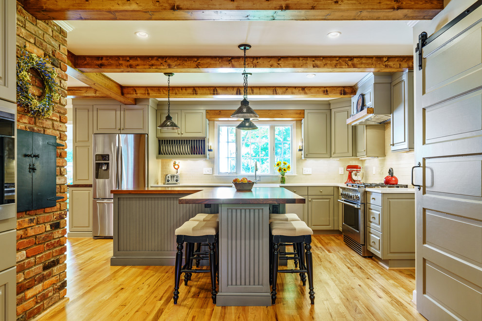 Inspiration for a traditional l-shaped kitchen in Other with raised-panel cabinets, grey cabinets, wood benchtops, beige splashback, stainless steel appliances, medium hardwood floors, with island, brown floor and brown benchtop.