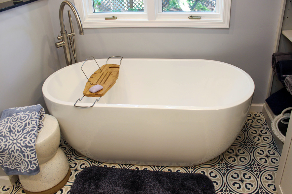 Inspiration for a mid-sized transitional master bathroom in Cleveland with flat-panel cabinets, grey cabinets, a freestanding tub, a corner shower, a two-piece toilet, gray tile, subway tile, grey walls, limestone floors, an undermount sink, engineered quartz benchtops, blue floor, a hinged shower door and blue benchtops.