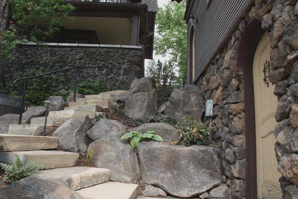 Photo of a large arts and crafts sloped partial sun garden in Seattle with a retaining wall and mulch.