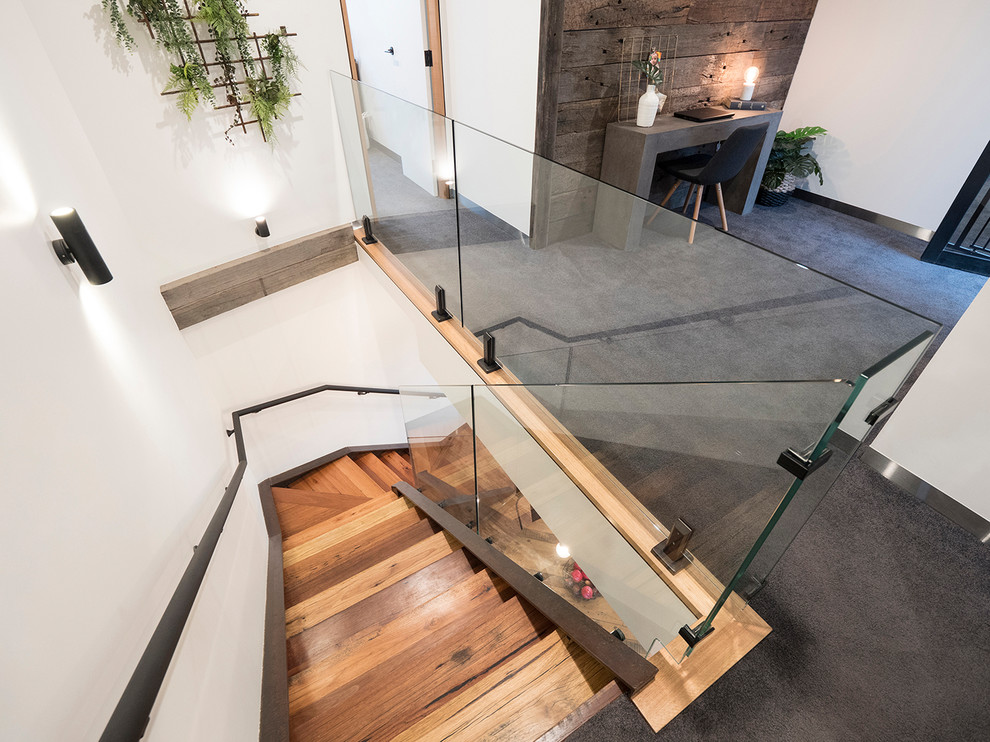 This is an example of a small contemporary wood l-shaped staircase in Other with metal risers and glass railing.