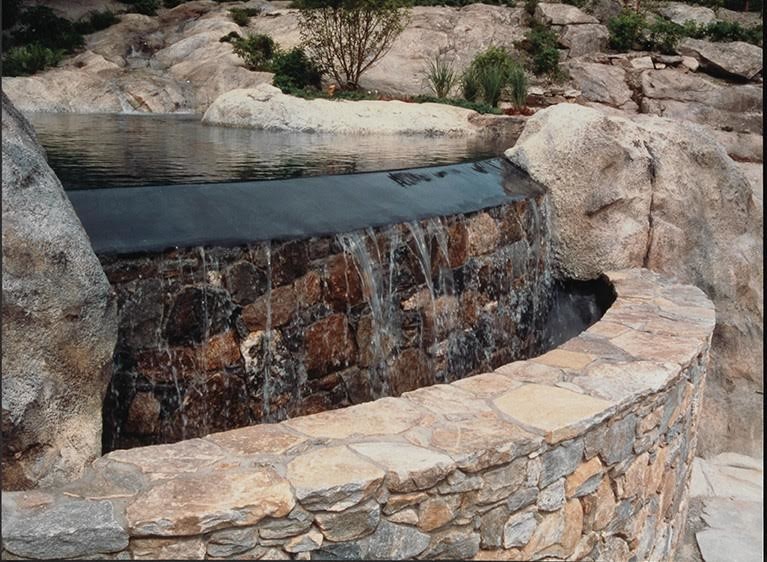 Large island style backyard stone and custom-shaped natural pool photo