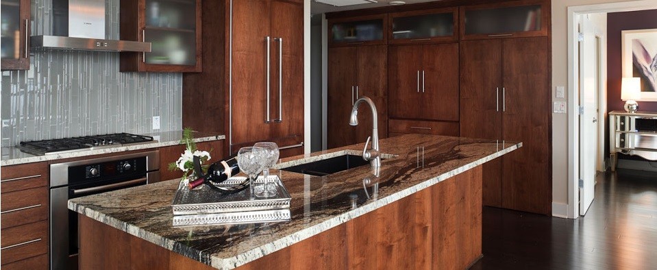 Eat-in kitchen - small transitional galley dark wood floor eat-in kitchen idea in Austin with an undermount sink, flat-panel cabinets, medium tone wood cabinets, granite countertops, gray backsplash, glass tile backsplash, stainless steel appliances and an island
