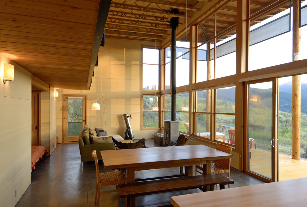 This is an example of a mid-sized country open plan dining in Seattle with beige walls and concrete floors.