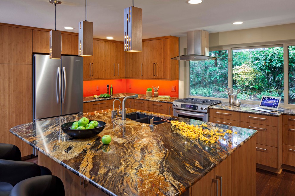 Large modern l-shaped open plan kitchen in Seattle with an undermount sink, flat-panel cabinets, medium wood cabinets, granite benchtops, orange splashback, bamboo floors and with island.