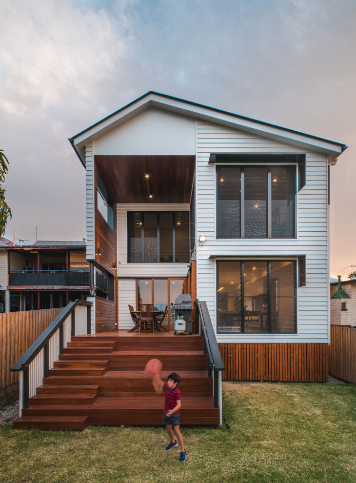 Mid-sized contemporary two-storey white house exterior in Brisbane with wood siding, a hip roof and a metal roof.