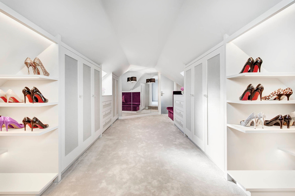 Design ideas for a large contemporary women's dressing room in London with shaker cabinets, white cabinets and carpet.
