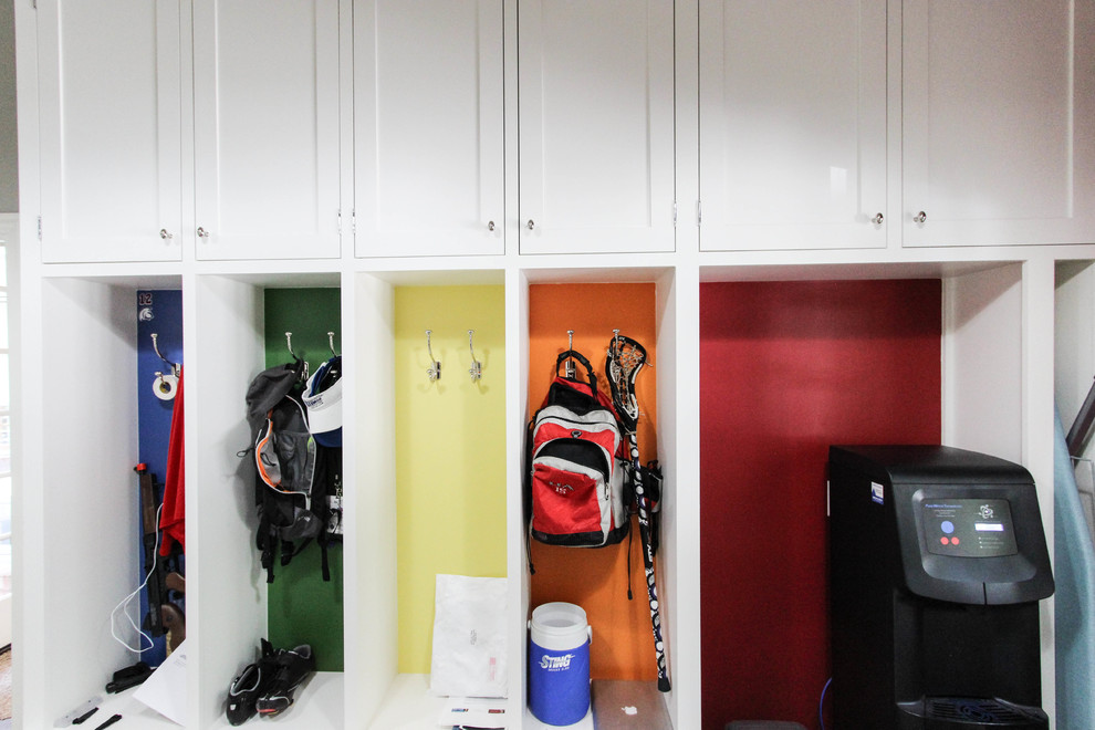 Example of a large transitional single-wall ceramic tile dedicated laundry room design with white cabinets, a side-by-side washer/dryer, an undermount sink, raised-panel cabinets, laminate countertops and red walls