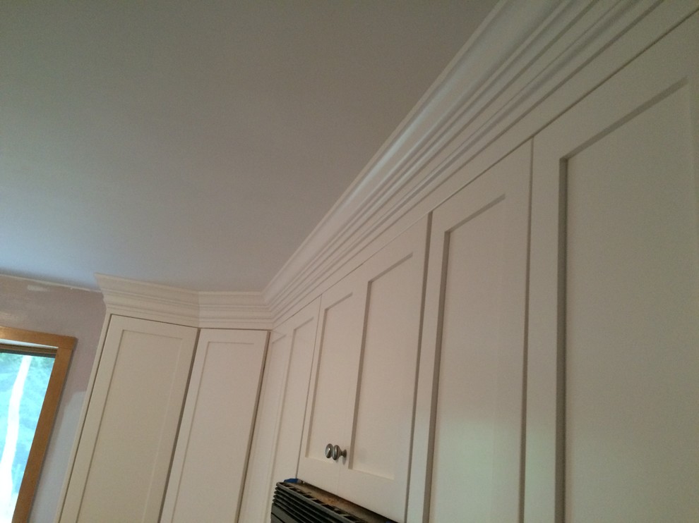 Inspiration for a mid-sized transitional l-shaped eat-in kitchen remodel in Boston with recessed-panel cabinets, white cabinets, granite countertops, glass tile backsplash and stainless steel appliances