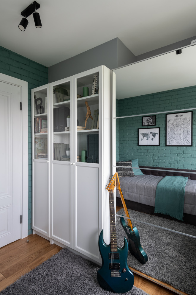 Inspiration pour une petite chambre d'enfant avec un mur vert, un sol en bois brun et un mur en parement de brique.