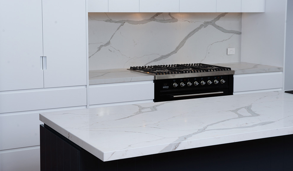 Inspiration for a contemporary kitchen in Sydney with quartz benchtops, white splashback, stone slab splashback, with island, flat-panel cabinets and white cabinets.