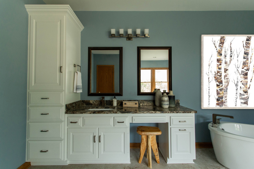 Inspiration for a country master bathroom in Cleveland with recessed-panel cabinets, white cabinets, a freestanding tub, an alcove shower, blue walls, ceramic floors, an undermount sink, engineered quartz benchtops, beige floor, a sliding shower screen, brown benchtops, an enclosed toilet, a double vanity and a built-in vanity.