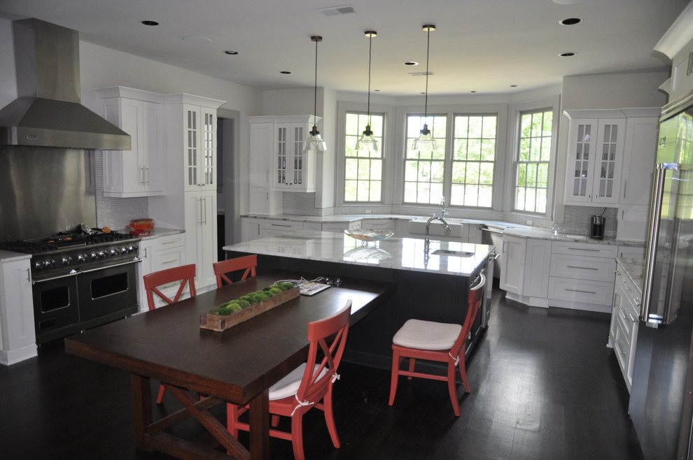 Inspiration for a mid-sized transitional u-shaped dark wood floor and brown floor enclosed kitchen remodel with an undermount sink, shaker cabinets, white cabinets, window backsplash, stainless steel appliances and an island