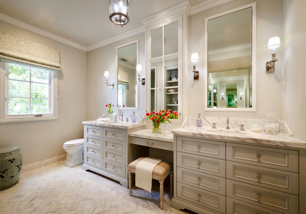 Inspiration for a coastal marble floor, white floor and double-sink bathroom remodel in Los Angeles with gray cabinets, a two-piece toilet, an undermount sink, marble countertops, white countertops, a built-in vanity, recessed-panel cabinets and beige walls