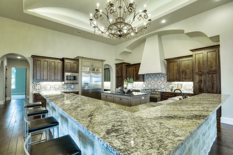 Inspiration for a huge transitional u-shaped dark wood floor eat-in kitchen remodel in Austin with a farmhouse sink, recessed-panel cabinets, dark wood cabinets, granite countertops, multicolored backsplash, porcelain backsplash, stainless steel appliances and two islands
