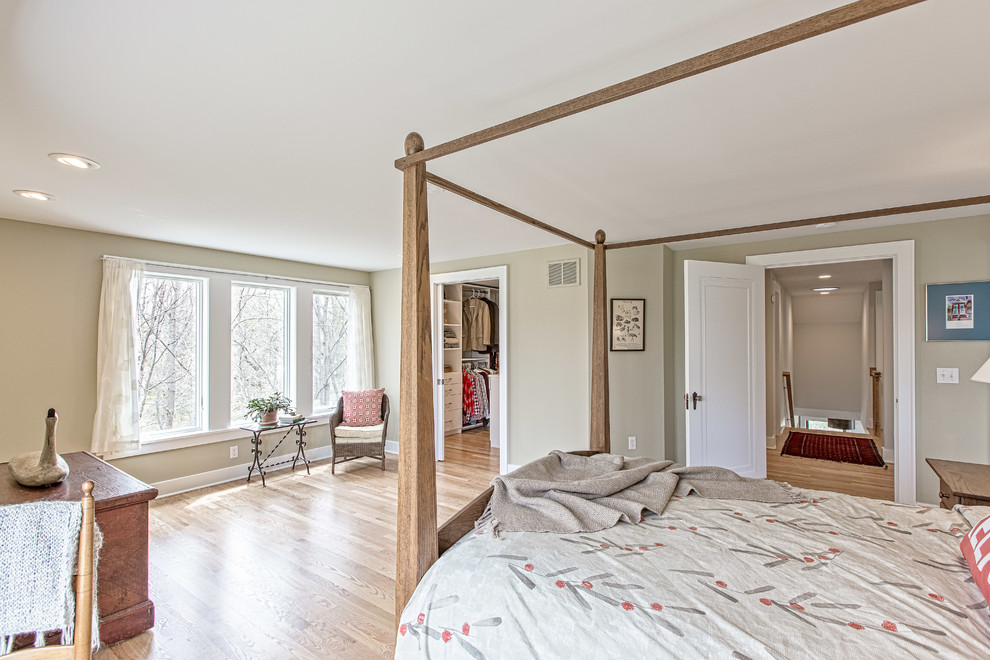 This is an example of a mid-sized arts and crafts master bedroom in Detroit with grey walls, light hardwood floors and no fireplace.