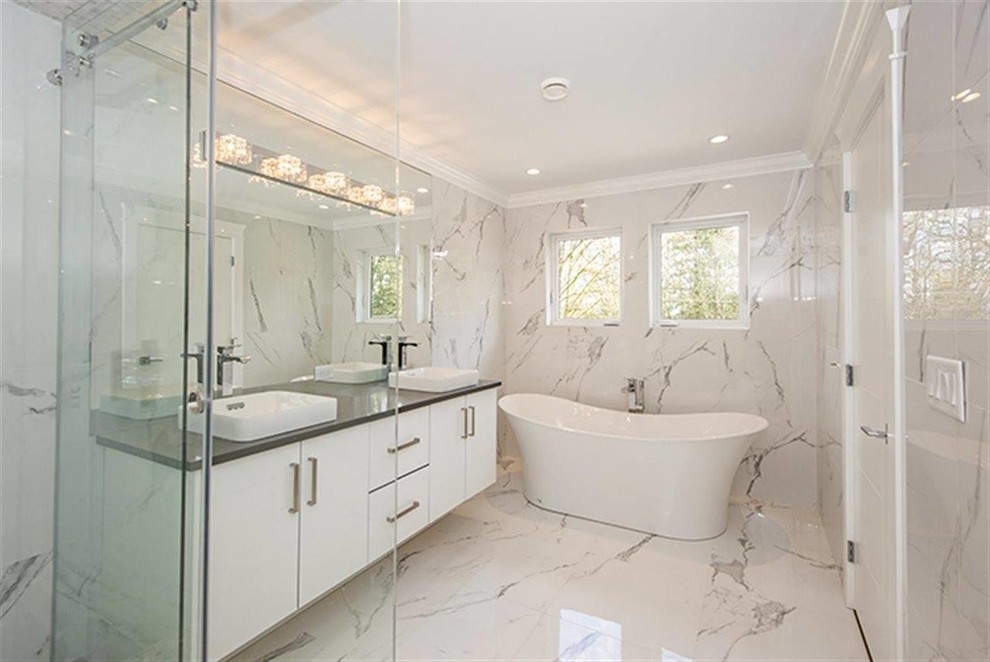 Large contemporary master bathroom in Vancouver with flat-panel cabinets, white cabinets, a freestanding tub, a corner shower, a two-piece toilet, white tile, porcelain tile, white walls, porcelain floors, a vessel sink and engineered quartz benchtops.