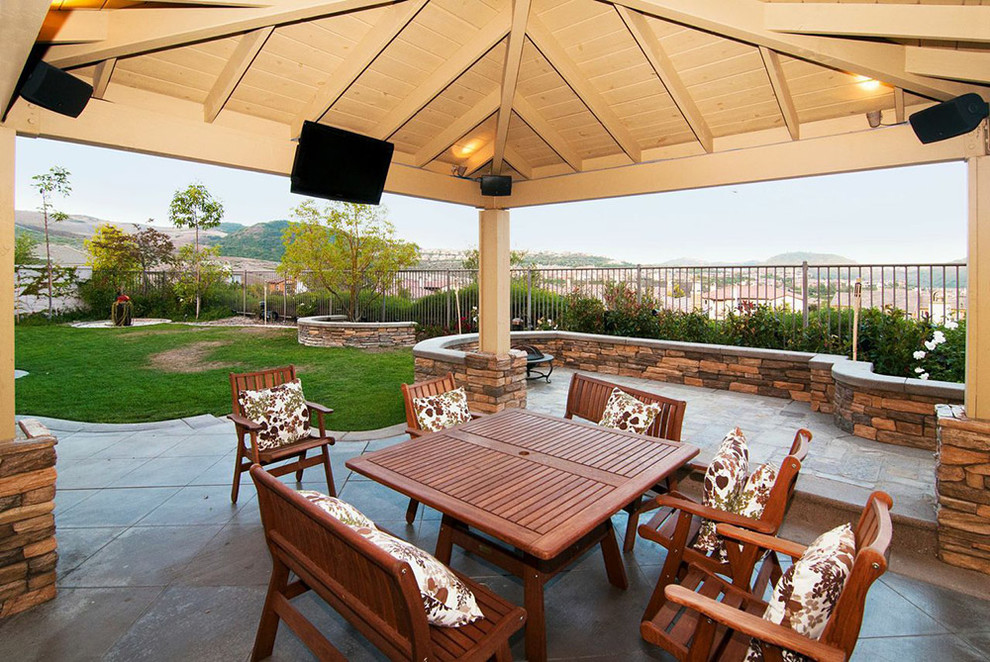 Example of a large transitional backyard patio design