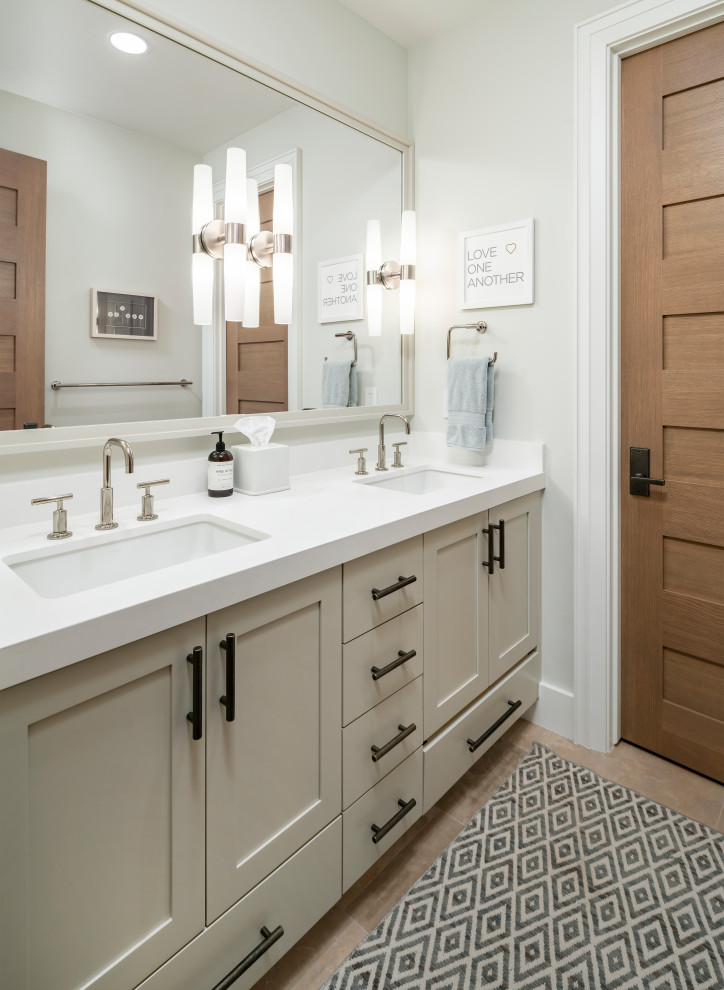 Design ideas for a large country kids bathroom in Salt Lake City with recessed-panel cabinets, beige cabinets, a freestanding tub, a shower/bathtub combo, a one-piece toilet, white tile, white walls, ceramic floors, an undermount sink, engineered quartz benchtops, beige floor, a hinged shower door and white benchtops.