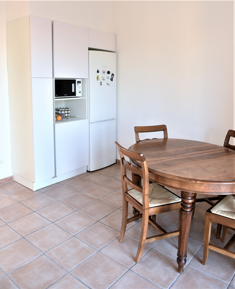 Ejemplo de cocina lineal contemporánea abierta sin isla con fregadero integrado, armarios con paneles lisos, puertas de armario blancas y suelo rosa