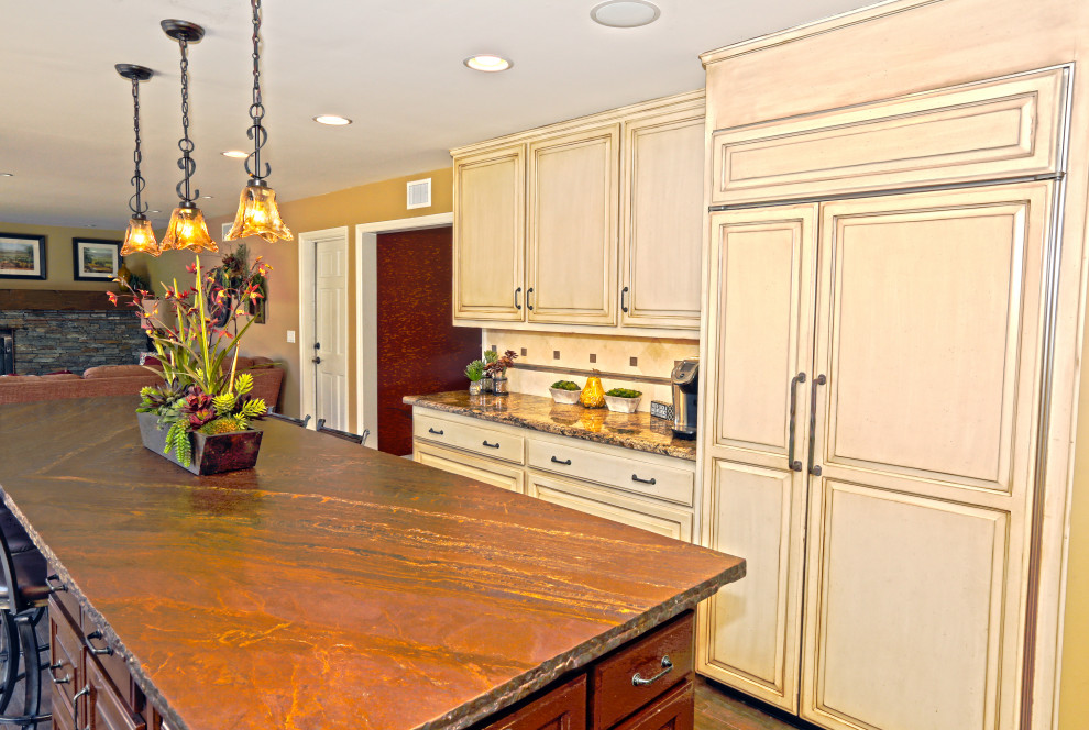 Bild på ett retro flerfärgad flerfärgat kök, med en nedsänkt diskho, skåp i slitet trä, granitbänkskiva, beige stänkskydd, stänkskydd i porslinskakel och rostfria vitvaror