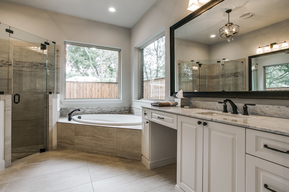 Inspiration for a mid-sized traditional master bathroom in Dallas with an undermount sink, raised-panel cabinets, white cabinets, granite benchtops, a drop-in tub, a corner shower, a one-piece toilet, beige tile and beige walls.