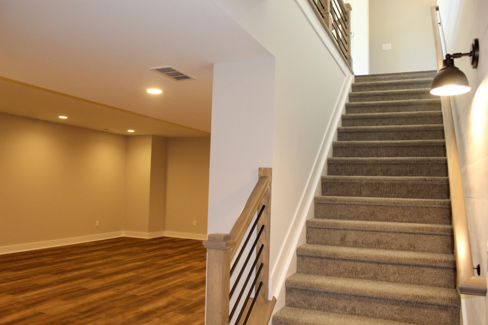 На фото: прямая лестница в стиле кантри с ступенями с ковровым покрытием, ковровыми подступенками, перилами из смешанных материалов и стенами из вагонки