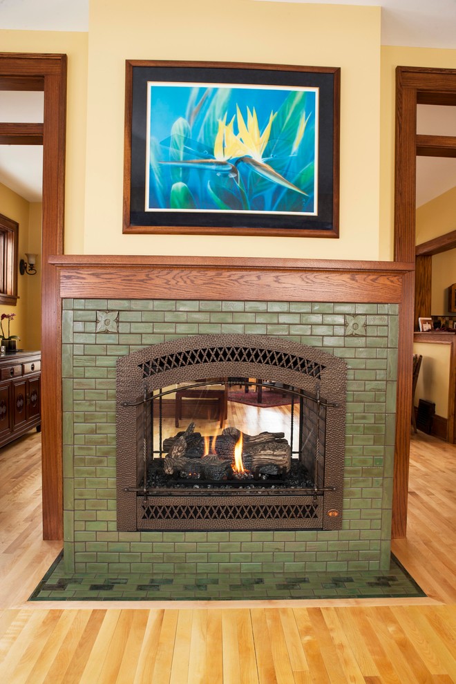 Arts and crafts enclosed living room in Minneapolis with ceramic floors, a two-sided fireplace and a tile fireplace surround.