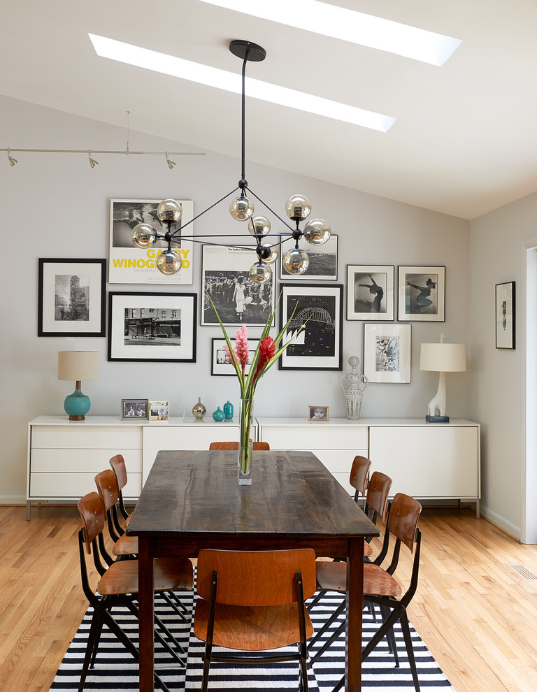 Photo of a midcentury dining room in Los Angeles with grey walls and light hardwood floors.