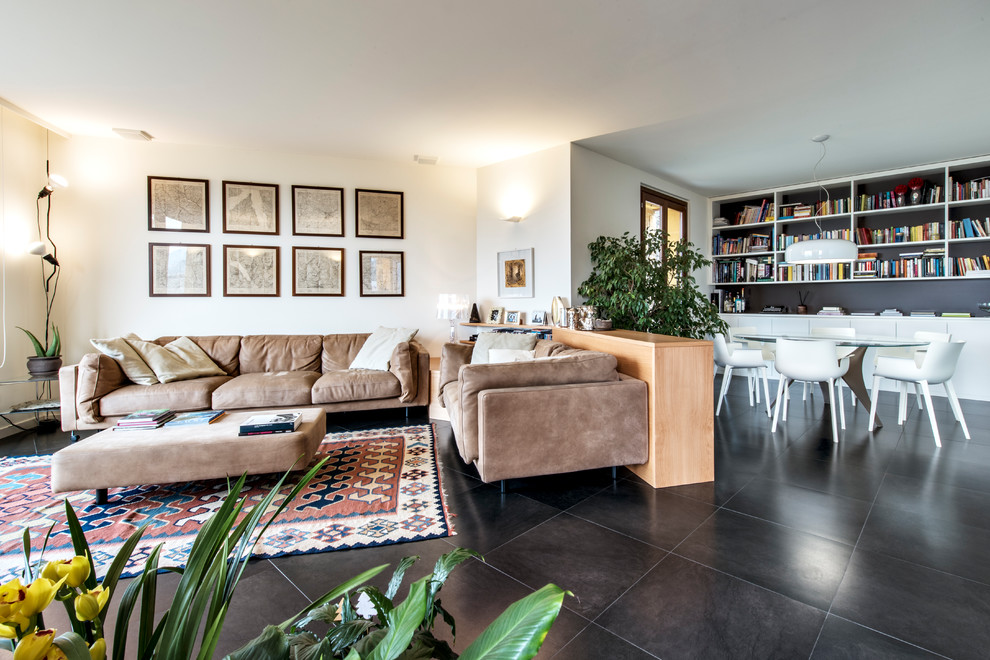Immagine di un grande soggiorno design aperto con libreria, pareti bianche, pavimento in ardesia, TV a parete e pavimento nero