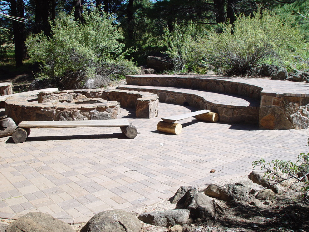 Mid-sized mountain style backyard brick patio photo in Phoenix with a fire pit and no cover