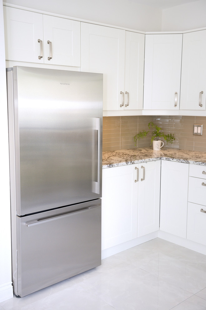 Example of a large transitional u-shaped porcelain tile enclosed kitchen design in Toronto with a farmhouse sink, white cabinets, beige backsplash, stainless steel appliances, no island, recessed-panel cabinets, quartzite countertops and ceramic backsplash