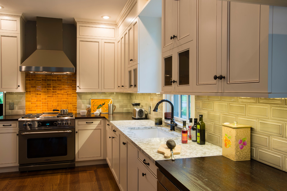 Example of a mid-sized transitional u-shaped medium tone wood floor eat-in kitchen design in New York with an undermount sink, recessed-panel cabinets, white cabinets, subway tile backsplash, stainless steel appliances, a peninsula, granite countertops and beige backsplash