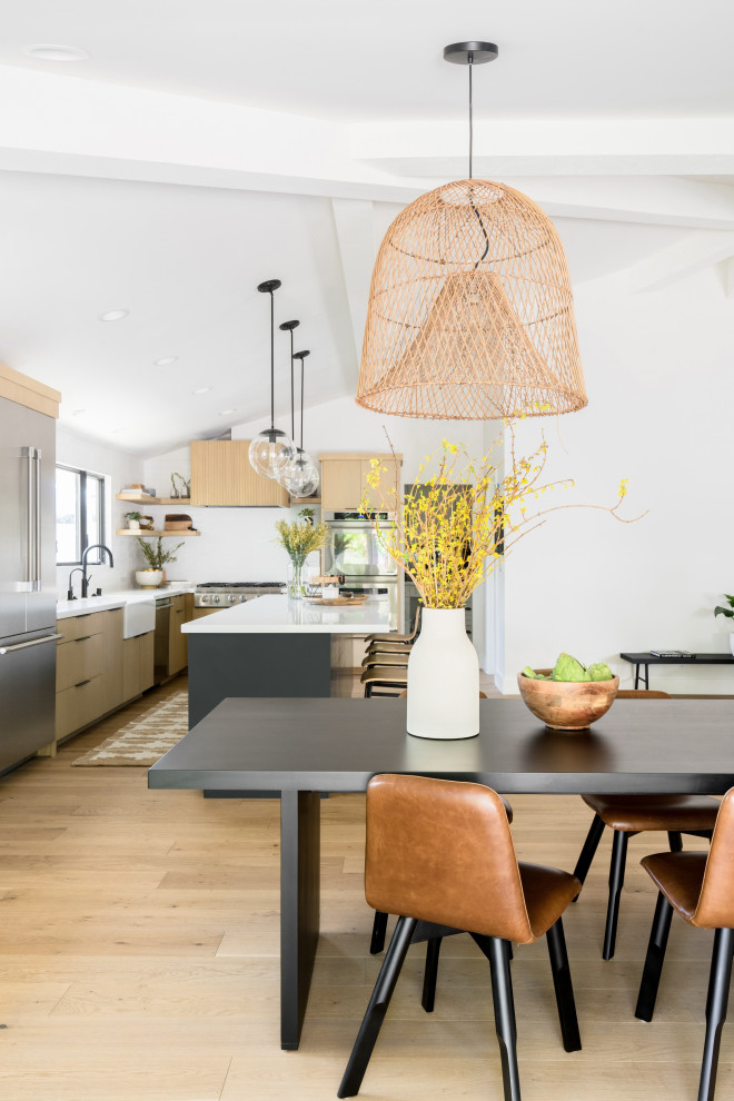 Immagine di una sala da pranzo aperta verso la cucina nordica di medie dimensioni con pareti bianche, parquet chiaro, pavimento marrone e soffitto a volta