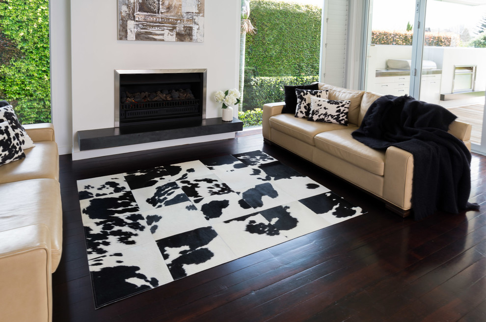 Large contemporary open concept living room in Sydney with white walls, dark hardwood floors and a standard fireplace.