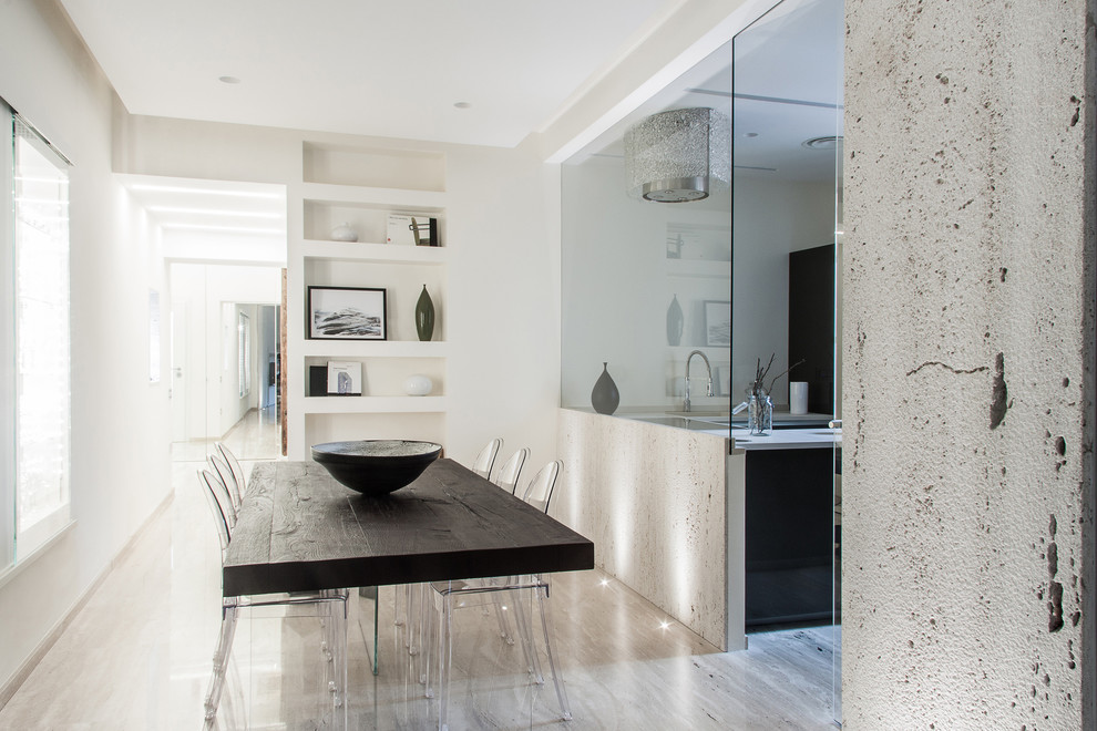 This is an example of a contemporary dining room in Venice with white walls and marble floors.