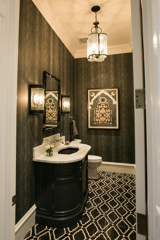 This is an example of a mid-sized transitional powder room in Baltimore with recessed-panel cabinets, black cabinets, a two-piece toilet, black walls, cement tiles, an undermount sink, marble benchtops, black floor and white benchtops.
