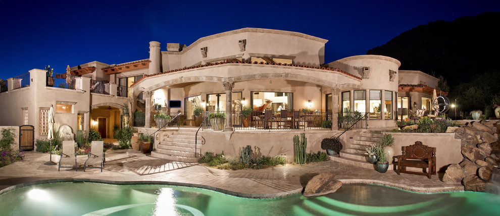 Expansive mediterranean two-storey adobe beige house exterior in Phoenix with a flat roof.