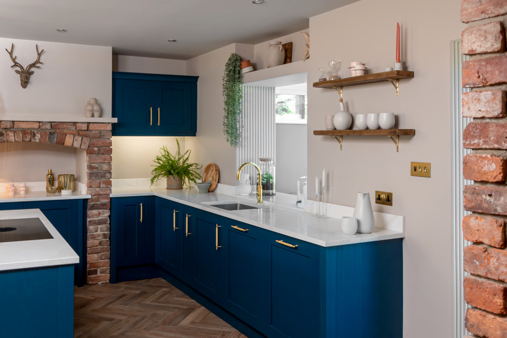 Photo of a mid-sized contemporary l-shaped kitchen in Other with shaker cabinets, blue cabinets, granite benchtops, white splashback, with island and white benchtop.