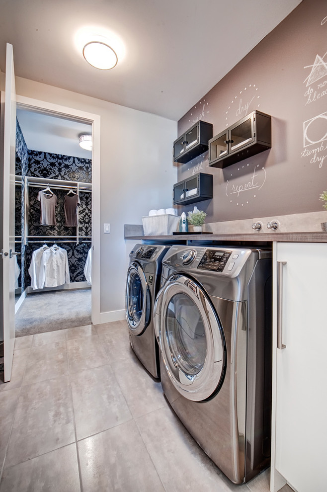Contemporary single-wall laundry room in Calgary with flat-panel cabinets, white cabinets, laminate benchtops, brown walls, ceramic floors and a side-by-side washer and dryer.