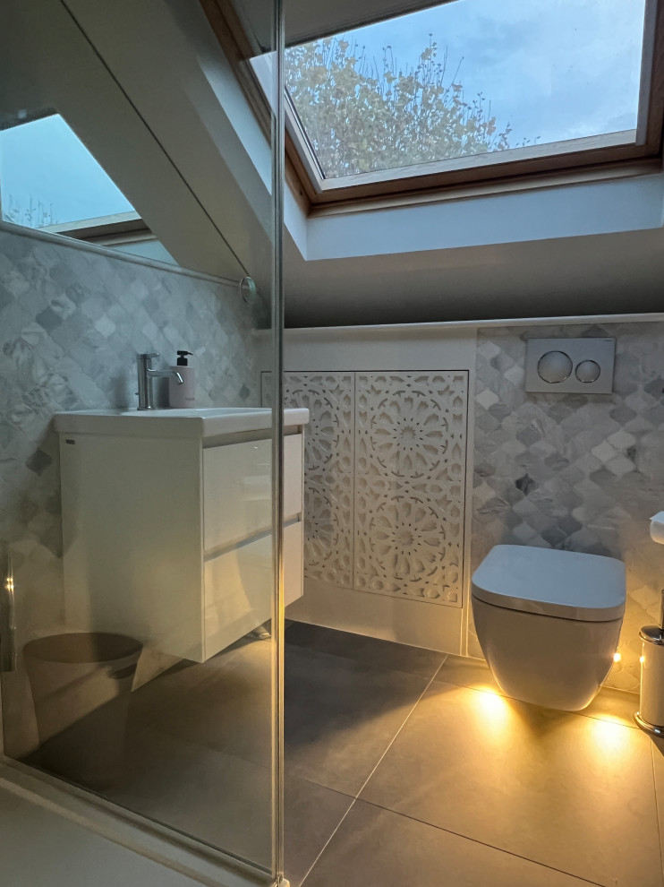 Small eclectic bathroom in London with grey tiles, a single sink and a floating vanity unit.