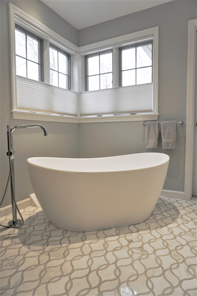 This is an example of a mid-sized transitional master bathroom in Other with flat-panel cabinets, brown cabinets, a freestanding tub, a corner shower, a bidet, gray tile, porcelain tile, grey walls, marble floors, an undermount sink, engineered quartz benchtops, white floor, a hinged shower door, grey benchtops, an enclosed toilet, a single vanity and a freestanding vanity.