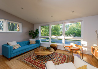 ミッドセンチュリースタイルのおしゃれなリビング (青いソファ