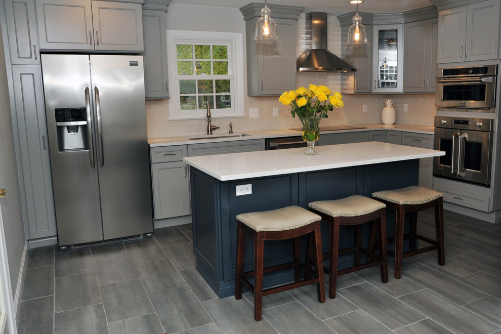 Example of a large transitional l-shaped gray floor and porcelain tile eat-in kitchen design in Philadelphia with recessed-panel cabinets, gray cabinets, white backsplash, stainless steel appliances, an island, an undermount sink, quartz countertops, ceramic backsplash and white countertops