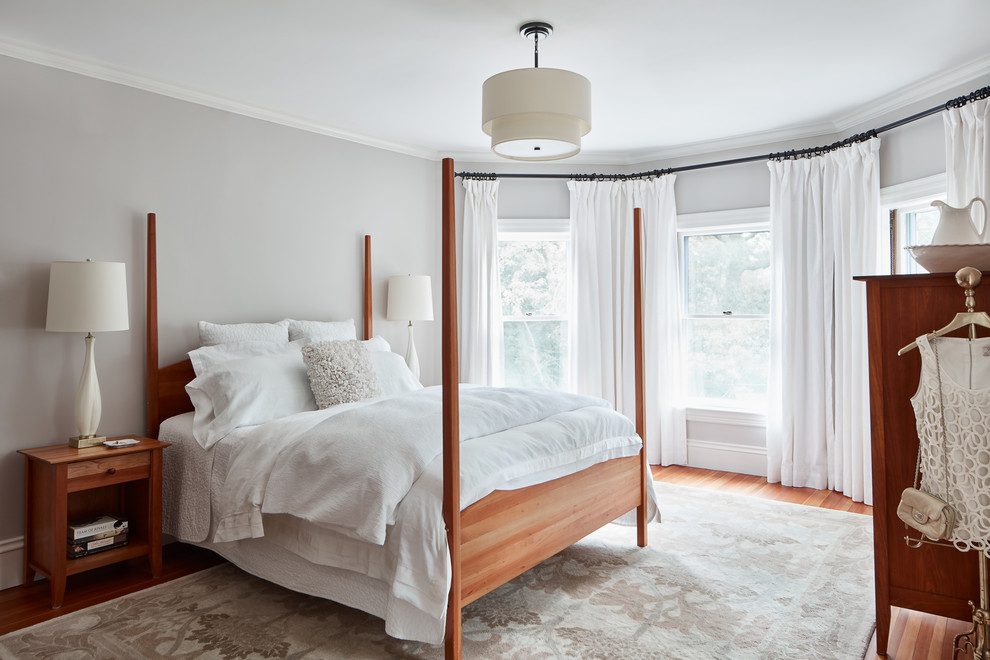 Example of a mid-sized classic master medium tone wood floor bedroom design in Boston with gray walls and no fireplace