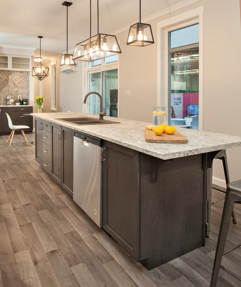 Small transitional galley vinyl floor and multicolored floor open concept kitchen photo with a drop-in sink, shaker cabinets, dark wood cabinets, laminate countertops, stainless steel appliances and an island