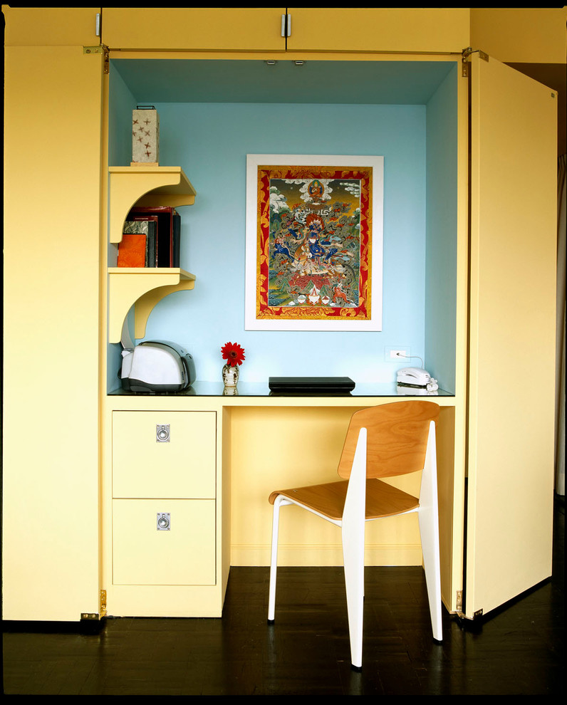 This is an example of a contemporary home office in New York with a built-in desk.