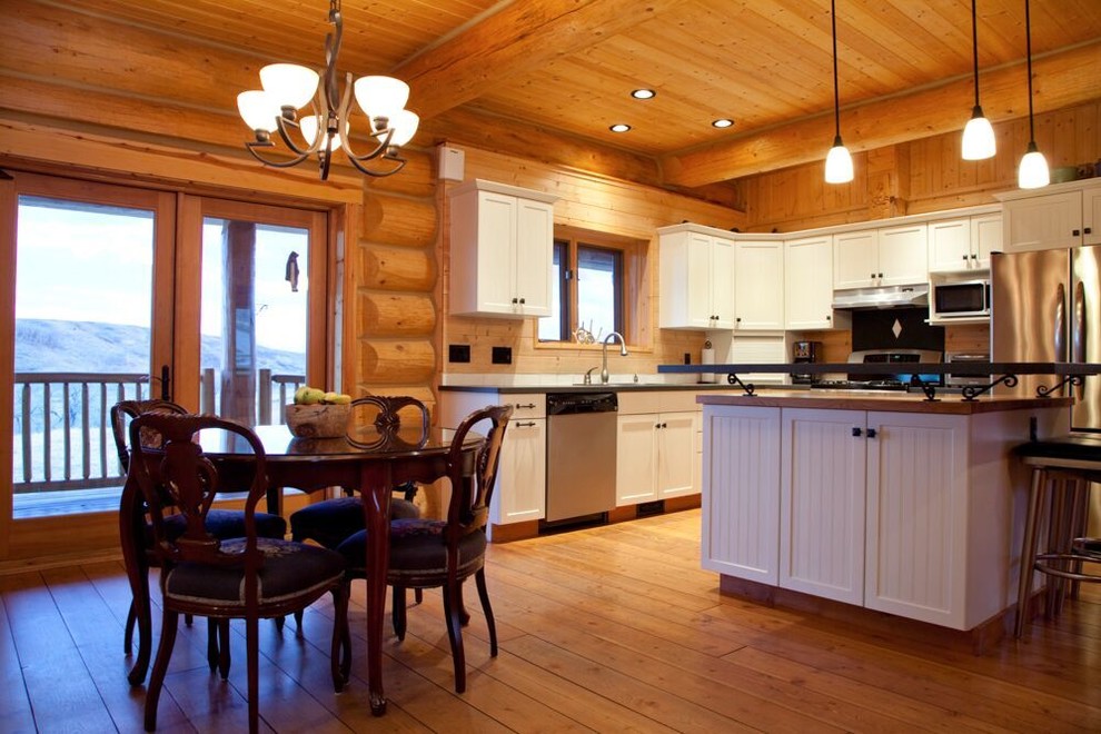 Mid-sized mountain style l-shaped medium tone wood floor kitchen photo with shaker cabinets, stainless steel appliances and an island